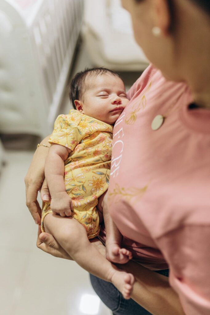 A loving mother gently holding her sleeping baby, expressing warmth and comfort.
