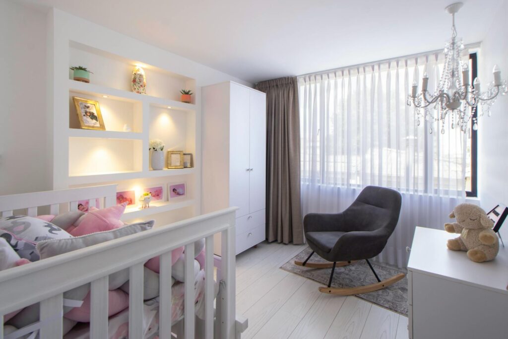 A well-designed nursery with blackout curtains, a white noise machine, and a comfortable crib.